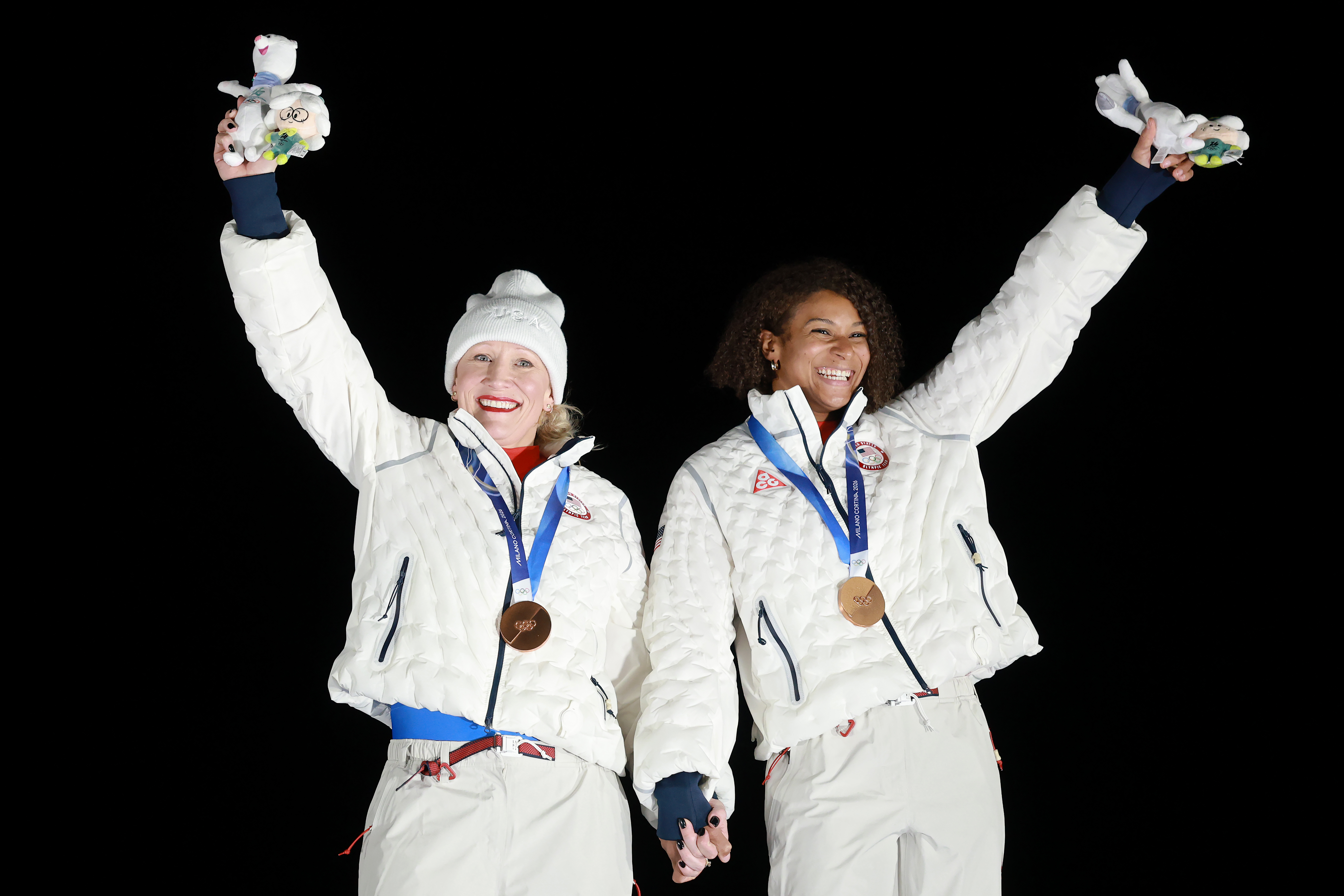 Bronze medalists Kaillie Armbruster Humphries and Jasmine Jones of Team United States celebrate on the podium during the medal ceremony for the Bobsleigh Two-Woman event.