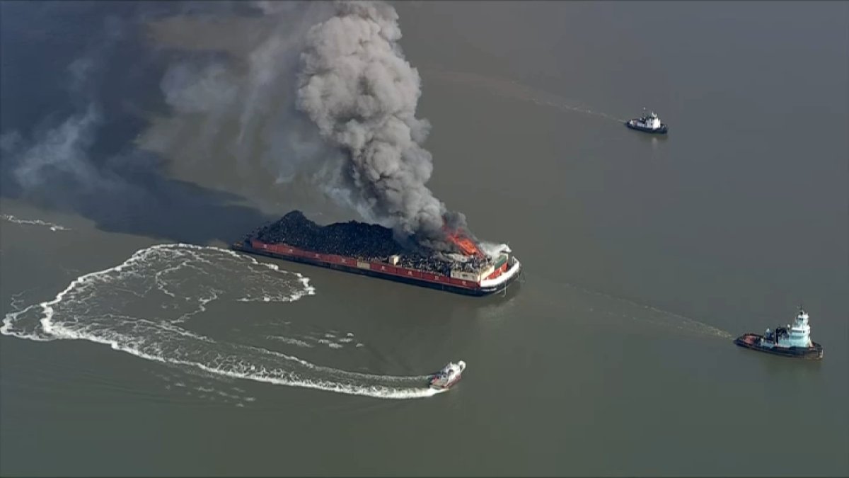 Fire crews work to extinguish burning barge on the Delaware River in Del.