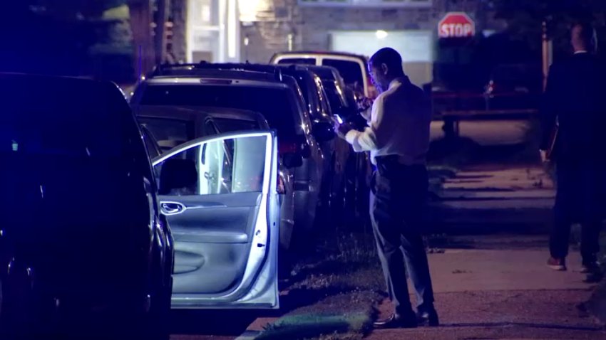An officers inspects a vehicle as a homicide investigation was underway along Griffith Street in Northeast Philly early Monday.
