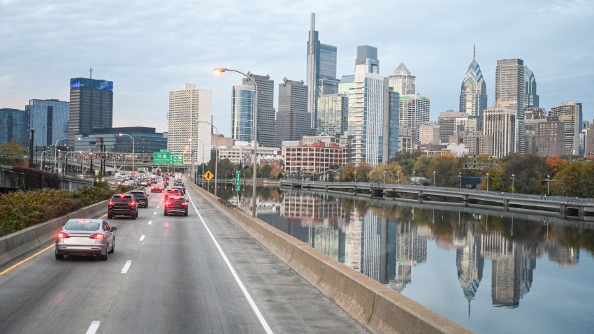 Skyline of Philadelphia city. Road with car traffic mama reflection of the city in Schuylkill river.