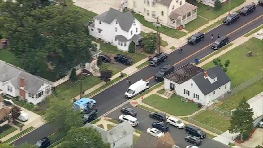 Police vehicles line the roadway at the scene of an investigation underway in Riverside, New Jersey early Thursday morning.