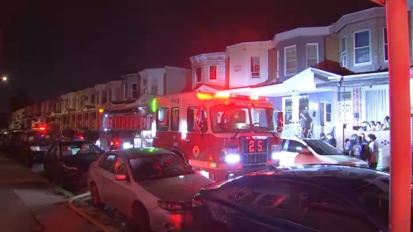 A firetruck sits in the roadway after, officials say, a rowhome caught fire near the intersection of E and East Tioga streets overnight.