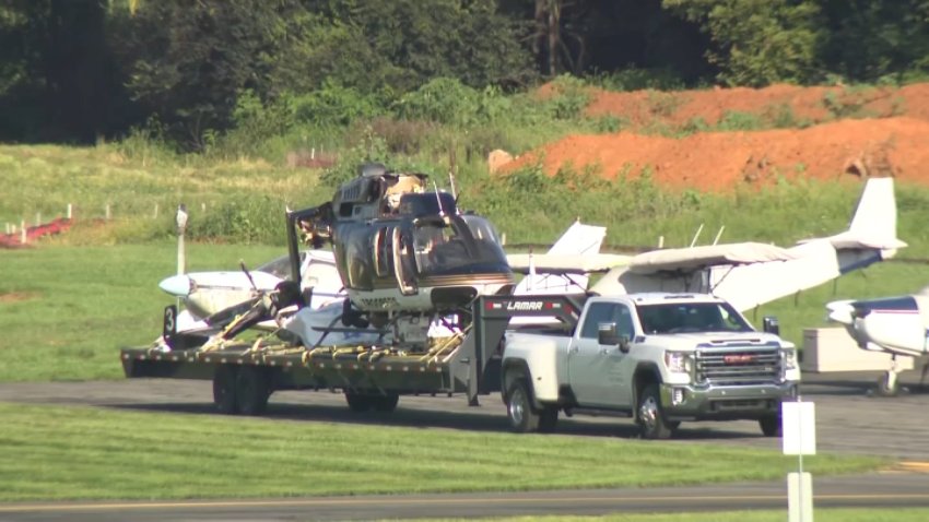 The wreckage of a Pa. State Police helicopter is piled onto a truck as investigators work at the scene of a deadly crash at the Carlisle Airport on Friday, Aug. 21, 2026.