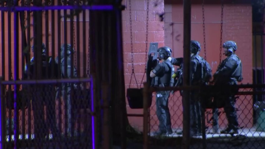 A Philadelphia Police Department SWAT team lined up before breaching an office door at Belfield Recreation Center in Philly's Ogontz neighborhood after, officials say, a man locked himself inside overnight.
