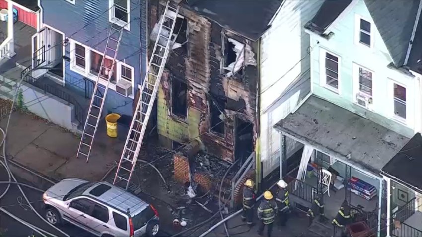 Firefighters respond early Wednesday after flames tore through a rowhome along Hewitt Street during a three-alarm fire in Trenton, New Jersey.