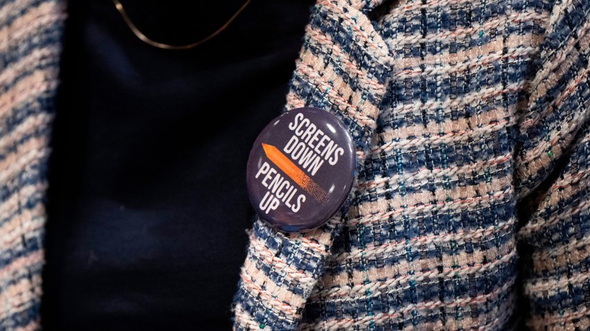 An attendee wears a "Screens Down, Pencils Up," button during a school board meeting at the Lower Merion School District Administration Building on May 11, 2026, in Ardmore, Pa.