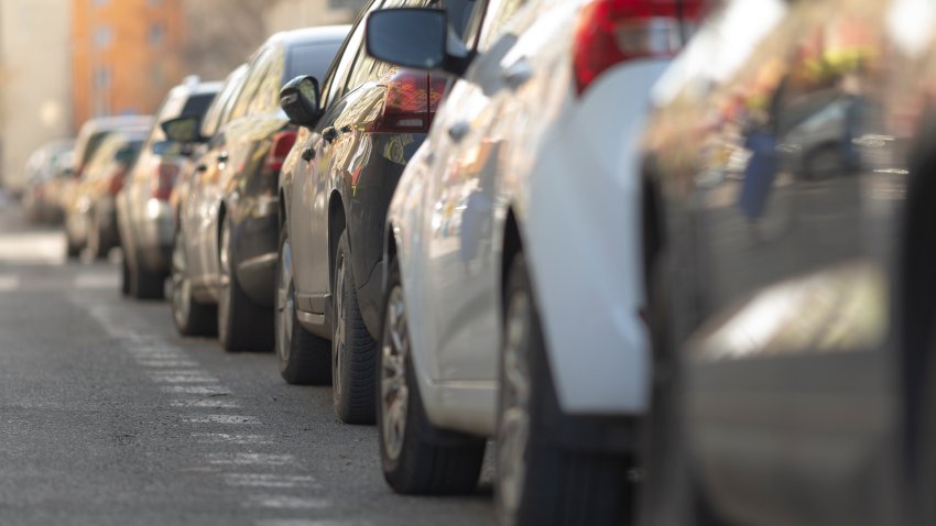 urban parking chaos, city streets crowded with parked cars, busy urban street filled with vehicles and pedestrians, chaotic city parking area with bustling crowds and vehicles